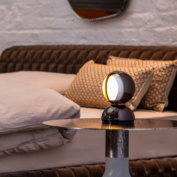 Artemide Eclisse table lamp on a bedside table in a cozy bedroom setting